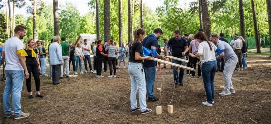 Большая корпоративная группа разделена на команды для тимбилдинга на природе